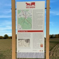 Infotafel über das Entringer Tor auf einem Feldweg, umgeben von Feldern und Bäumen, unter blauem Himmel., © Natur.Nah. Schönbuch & Heckengäu