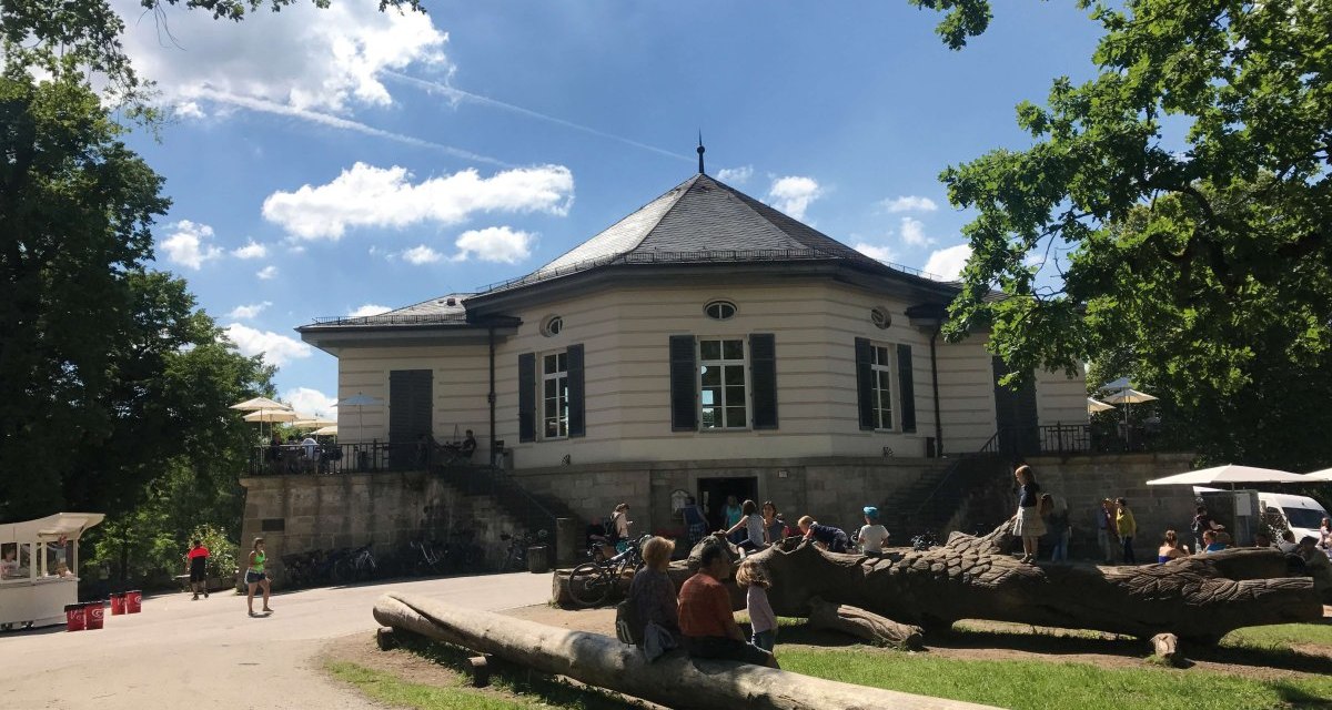 Das B&auml;renschl&ouml;ssle in einem sonnigen Park. Menschen sitzen und spielen auf Baumst&auml;mmen, w&auml;hrend andere spazieren gehen. Der Himmel ist blau mit Wolken., &copy; Stuttgart-Marketing GmbH