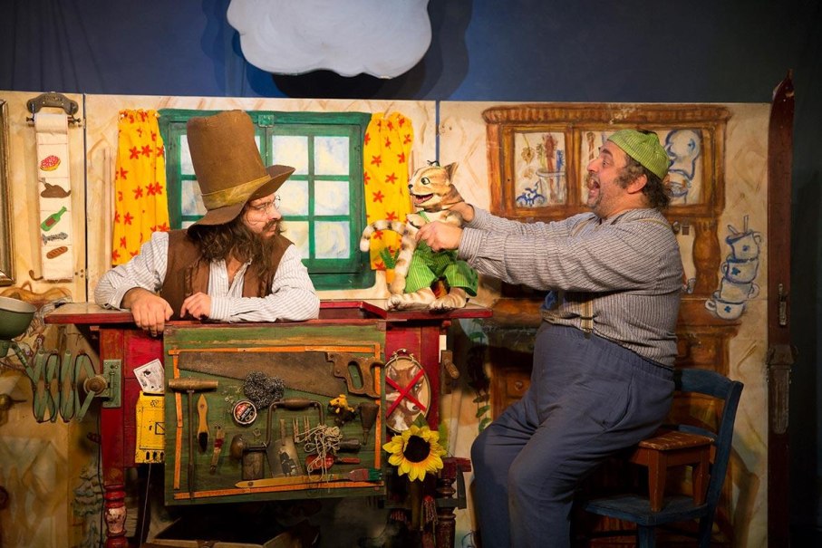 Theaterszene aus "Pettersson kriegt Weihnachtsbesuch" mit zwei Schauspielern und einer Katze als Puppe in einer gemütlichen Kulisse., © Pettersson kriegt Weihnachtsbesuch - Theater Kuckucksheim, Foto: Andreas Riedel Theaterszene aus "Pettersson kriegt Weihnachtsbesuch" mit zwei Schauspielern und einer Katze als Puppe in einer gemütlichen Kulisse., © Pettersson kriegt Weihnachtsbesuch - Theater Kuckucksheim, Foto: Andreas Riedel