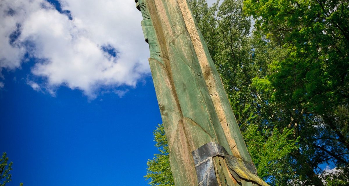 Eine hohe Baumskulptur aus Holz ragt in den blauen Himmel, umgeben von grünen Bäumen und Häusern im Hintergrund., © Remstal Tourismus e.V. Eine hohe Baumskulptur aus Holz ragt in den blauen Himmel, umgeben von grünen Bäumen und Häusern im Hintergrund., © Remstal Tourismus e.V.
