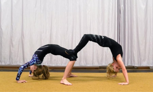 Zwei Kinder in sportlicher Kleidung machen eine Akrobatik&uuml;bung in einer Turnhalle. Sie stehen in Br&uuml;ckenposition und st&uuml;tzen sich gegenseitig., &copy; Kunstschule Labyrinth