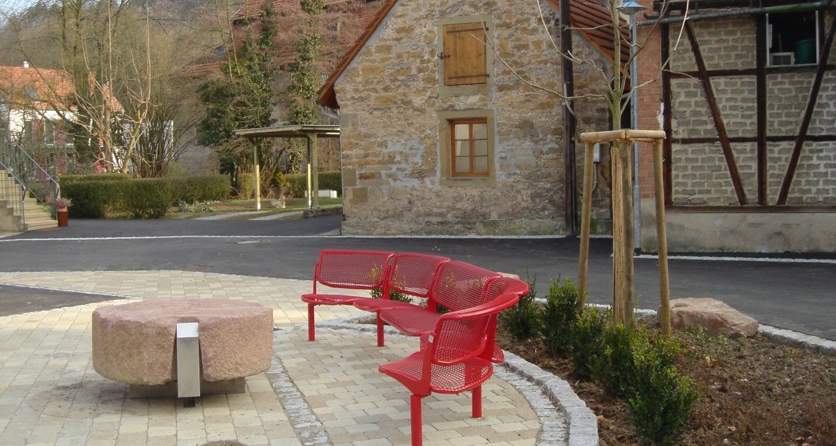 Gepflasterter Platz mit roten Bänken und rundem Steintisch, umgeben von Fachwerkhäusern und Bäumen. Datum auf dem Bild: 18.12.2007., © Land der 1000 Hügel - Kraichgau-Stromberg Gepflasterter Platz mit roten Bänken und rundem Steintisch, umgeben von Fachwerkhäusern und Bäumen. Datum auf dem Bild: 18.12.2007., © Land der 1000 Hügel - Kraichgau-Stromberg