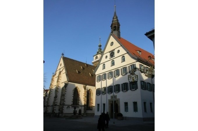 Historische Gebäude in Bad Cannstatt, darunter eine Kirche und ein Fachwerkhaus, bei klarem Himmel und Sonnenschein., © Cool-Tours StattReisen