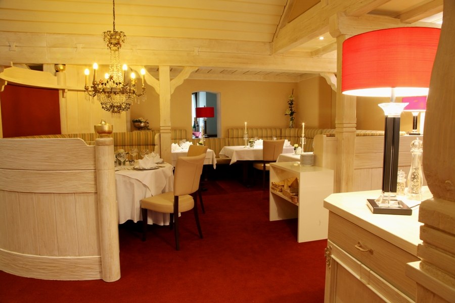Elegantes Restaurant mit Kronleuchter, roten Lampenschirmen und gedeckten Tischen. Holzmöbel und Teppichboden schaffen eine warme Atmosphäre., © Hotel Fuchsen Elegantes Restaurant mit Kronleuchter, roten Lampenschirmen und gedeckten Tischen. Holzmöbel und Teppichboden schaffen eine warme Atmosphäre., © Hotel Fuchsen