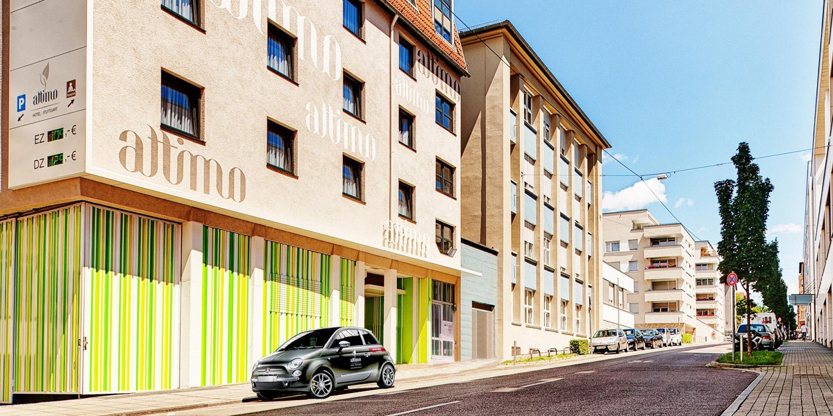 Außenansicht eines Hotels mit dem Namen 'attimo', bunte Fassade, parkendes Auto davor., © attimo