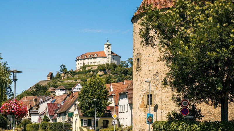 Der Pulverturm in Vaihingen an der Enz mit der Burg im Hintergrund, umgeben von B&auml;umen und H&auml;usern unter blauem Himmel., &copy; Stuttgart-Marketing GmbH, Sarah Schmid