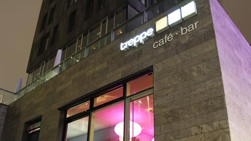 Modernes Geb&auml;ude mit der Aufschrift 'treppe caf&eacute; &middot; bar' und beleuchteten Fenstern in der Nacht., &copy; Caf&eacute; Treppe, Stuttgart