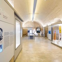 Innenansicht der Stauffenberg-Erinnerungsstätte mit modernen Ausstellungsstücken, Informationstafeln und Bildschirmen in einem gewölbten Raum., © Haus der Geschichte Baden-Württemberg Innenansicht der Stauffenberg-Erinnerungsstätte mit modernen Ausstellungsstücken, Informationstafeln und Bildschirmen in einem gewölbten Raum., © Haus der Geschichte Baden-Württemberg