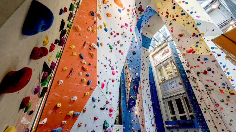 Bunte Klettergriffe an hohen W&auml;nden in der Kletterhalle Cityrock. Die W&auml;nde sind in verschiedenen Farben gestaltet und bieten vielf&auml;ltige Routen., &copy; Kletterhalle Cityrock