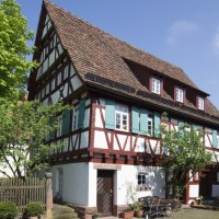 Fachwerkhaus mit gr&uuml;nen Fensterl&auml;den, umgeben von B&auml;umen und Gartenm&ouml;beln. Sonniger Tag mit blauem Himmel., &copy; Stadtverwaltung Weil der Stadt