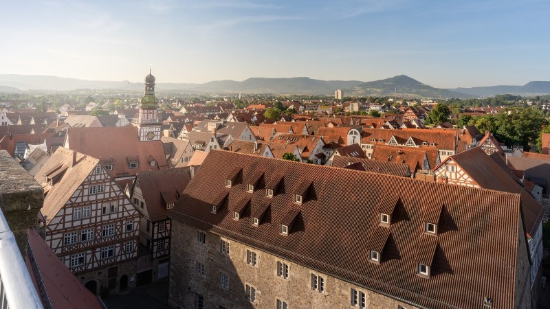 Panoramablick &uuml;ber Kirchheim unter Teck mit roten D&auml;chern, Fachwerkh&auml;usern und einem Kirchturm. Im Hintergrund sind H&uuml;gel und blauer Himmel zu sehen., &copy; Stuttgart-Marketing GmbH, Martina Denker