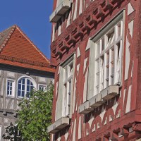 Fachwerkhäuser mit roten und grauen Balken, weiße Fenster und ein rotes Ziegeldach vor klarem, blauem Himmel., © Stadt Vaihingen an der Enz Fachwerkhäuser mit roten und grauen Balken, weiße Fenster und ein rotes Ziegeldach vor klarem, blauem Himmel., © Stadt Vaihingen an der Enz