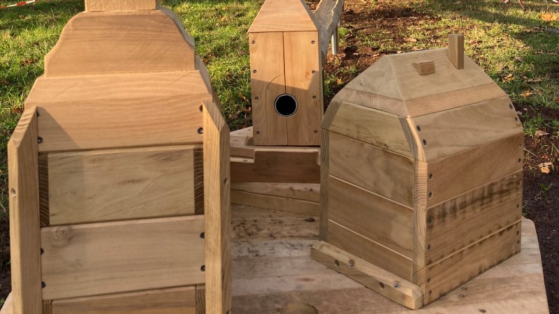 Holzvogelh&auml;user und ein Kletterger&uuml;st auf einem Spielplatz im Gr&uuml;nen. Herbstliche B&auml;ume im Hintergrund, blauer Himmel., &copy; Stadt Herrenberg