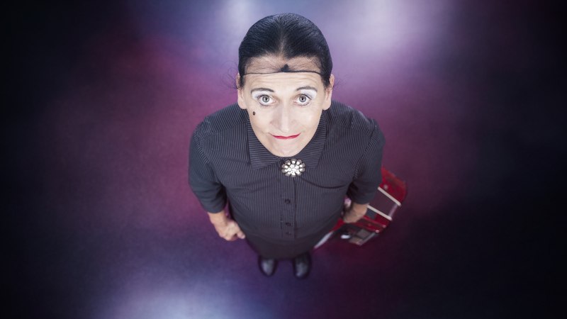 Frau in schwarzem Kleid mit Brosche und Akkordeon, von oben fotografiert. Der Hintergrund ist dunkel mit lila Lichtakzenten., &copy; Dieselstrasse Kulturzentrum e.V.