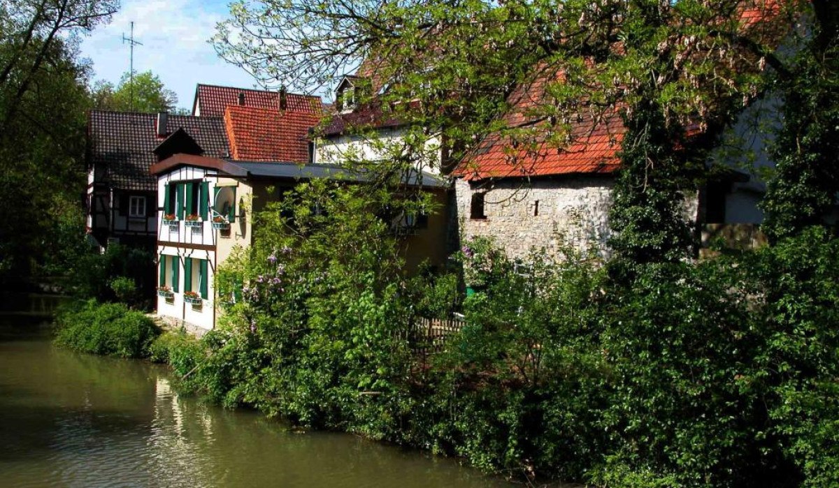Fachwerkhäuser in der Waiblinger Altstadt, umgeben von grünen Bäumen, am Ufer der Rems. Die Dächer sind mit roten Ziegeln gedeckt., © Waiblingen - Stuttgart-Marketing GmbH Fachwerkhäuser in der Waiblinger Altstadt, umgeben von grünen Bäumen, am Ufer der Rems. Die Dächer sind mit roten Ziegeln gedeckt., © Waiblingen - Stuttgart-Marketing GmbH