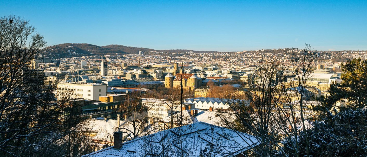 Winterlicher Panoramablick auf Stuttgart mit schneebedeckten D&auml;chern und klarem Himmel. Die Stadt erstreckt sich bis zu den bewaldeten H&uuml;geln im Hintergrund., &copy; Stuttgart-Marketing GmbH, Sarah Schmid
