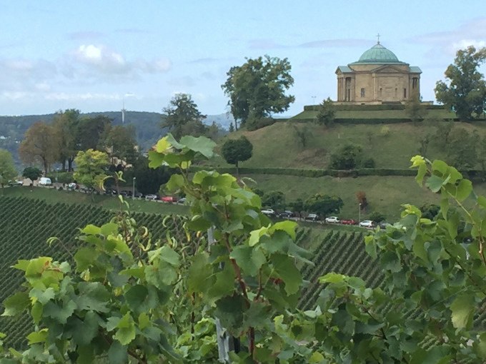 Weinberge in Stuttgart-Uhlbach mit einem Mausoleum auf einem H&uuml;gel im Hintergrund, umgeben von B&auml;umen und blauem Himmel., &copy; Weingenuss Stuttgart