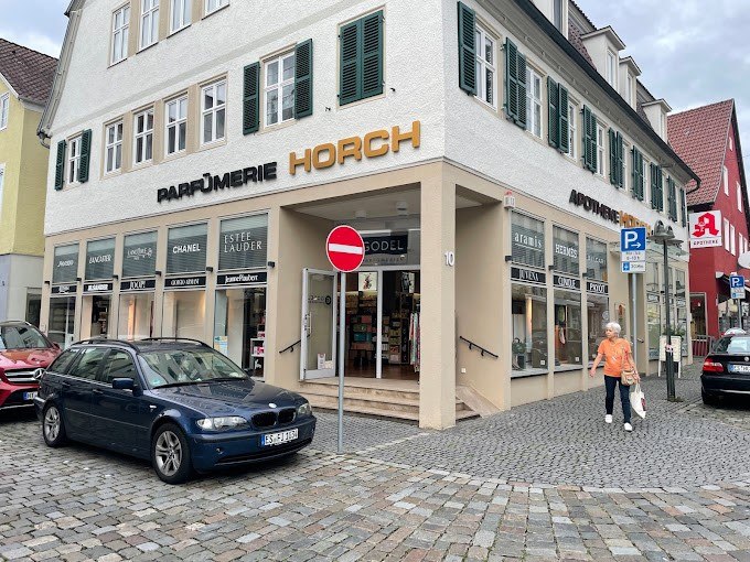 Parfümerie Godel in Nürtingen, Eckgebäude mit Schaufenstern, Autos parken davor, Passant geht vorbei., © Parfümerie Godel