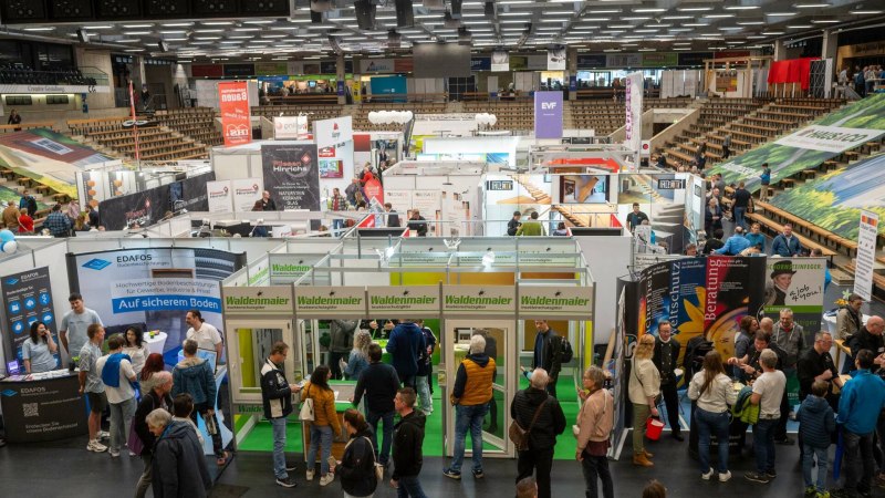 Besucher auf einer Baumesse mit zahlreichen Ständen und Ausstellern, die Produkte und Dienstleistungen rund ums Bauen und Wohnen präsentieren. Besucher auf einer Baumesse mit zahlreichen Ständen und Ausstellern, die Produkte und Dienstleistungen rund ums Bauen und Wohnen präsentieren.