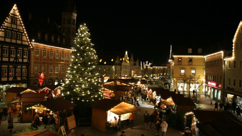 Weihnachtsmarkt bei Nacht mit beleuchteten Ständen und einem großen Weihnachtsbaum in der Mitte., © Für die Bildrechte: Amt für Medien und Kommunikation Schwäbisch Gmünd