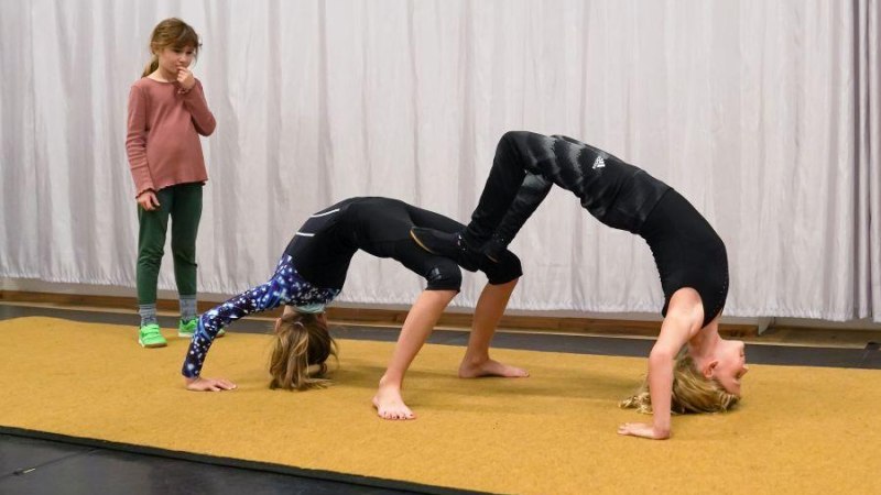 Zwei Kinder machen eine Brücke auf einer Matte, während ein weiteres Kind zuschaut. Zirkus-Workshop in Ludwigsburg., © Kunstschule Labyrinth