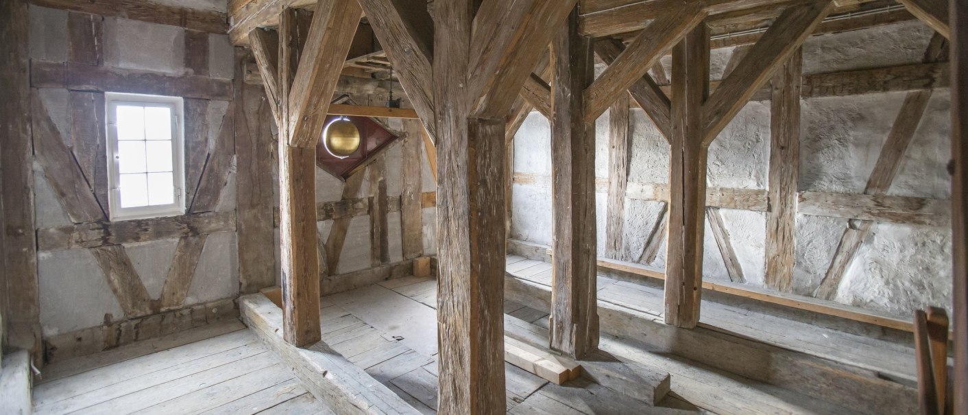 Innenansicht eines historischen Fachwerkraums mit sichtbaren Holzbalken und kleinem Fenster im Rathaus Kirchheim unter Teck., © Torsten Wenzler