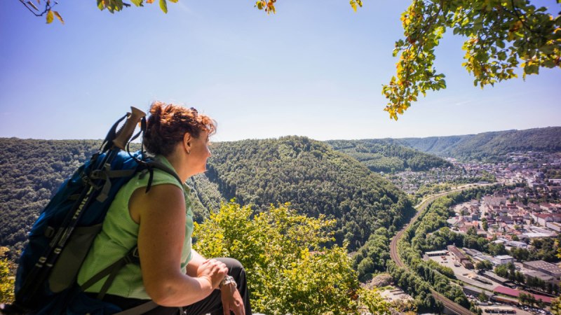 Frau mit Rucksack genießt den Ausblick vom Anwandfelsen auf Geislingen und das umliegende bewaldete Tal., © Stadt Geislingen an der Steige