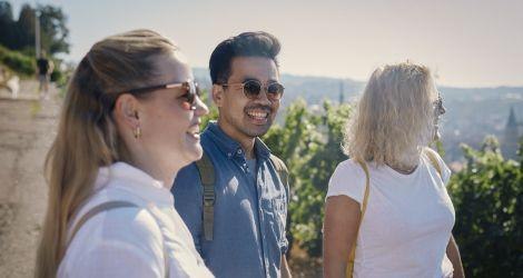 Drei Personen genie&szlig;en einen sonnigen Tag im Freien, umgeben von Weinbergen. Sie l&auml;cheln und tragen Sonnenbrillen., &copy; Familiensonntag. Foto: Teamwerk