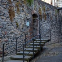 Alte Stadtmauer mit Treppe, Laterne und zwei Personen in einer engen Gasse. Eine Brücke verbindet Gebäude über der Mauer., © Stuttgart-Marketing GmbH, Foto: Achim Mende Alte Stadtmauer mit Treppe, Laterne und zwei Personen in einer engen Gasse. Eine Brücke verbindet Gebäude über der Mauer., © Stuttgart-Marketing GmbH, Foto: Achim Mende