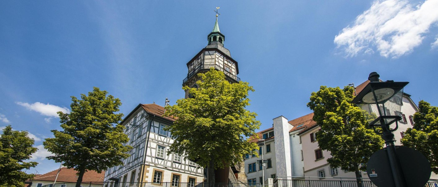 Historisches Gebäude mit Turm und Fachwerk in Backnang, umgeben von Bäumen und blauem Himmel., © Stuttgart-Marketing GmbH, Sarah Schmid Historisches Gebäude mit Turm und Fachwerk in Backnang, umgeben von Bäumen und blauem Himmel., © Stuttgart-Marketing GmbH, Sarah Schmid
