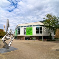 Moderne Skulptur vor dem Schauspielhaus mit gro&szlig;en Fenstern und Plakaten f&uuml;r 'Italienische Nacht'. Wolkenbedeckter Himmel, B&auml;ume und Baukr&auml;ne im Hintergrund., &copy; Bj&ouml;rn Klein