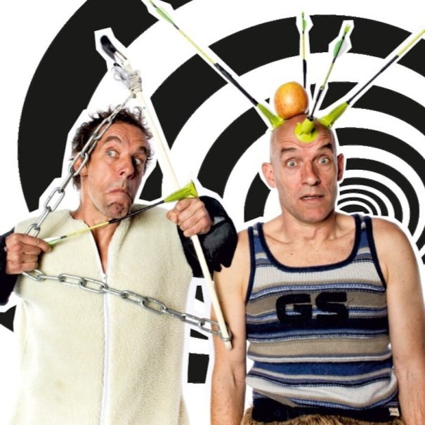 Zwei Männer in lustigen Posen, einer mit Pfeilen und Apfel auf dem Kopf, der andere mit Ketten um den Körper, vor spiralförmigem Hintergrund., © Mauerwerk GmbH Zwei Männer in lustigen Posen, einer mit Pfeilen und Apfel auf dem Kopf, der andere mit Ketten um den Körper, vor spiralförmigem Hintergrund., © Mauerwerk GmbH