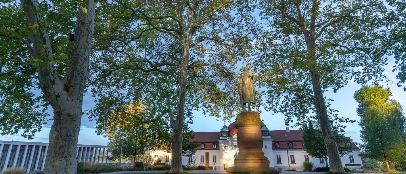 Das Schillerdenkmal steht vor dem Schiller-Nationalmuseum in Marbach, umgeben von hohen Bäumen und grünem Rasen., © Stuttgart-Marketing GmbH, Martina Denker