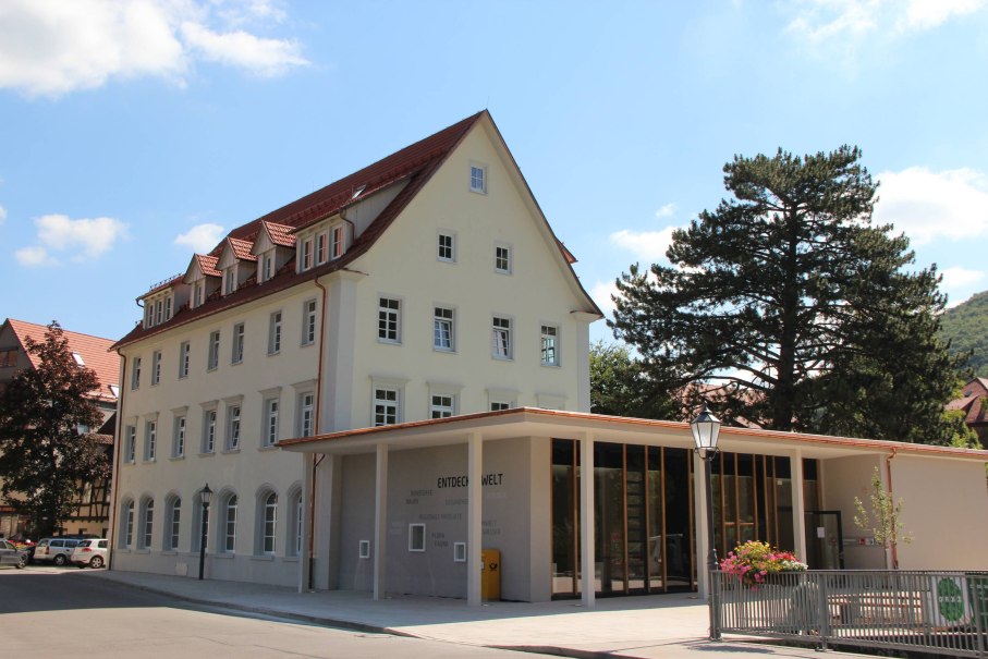 Ein modernes Gebäude mit großen Fenstern und traditionellem Dach, umgeben von Bäumen. Der Himmel ist klar und blau. Ein modernes Gebäude mit großen Fenstern und traditionellem Dach, umgeben von Bäumen. Der Himmel ist klar und blau.