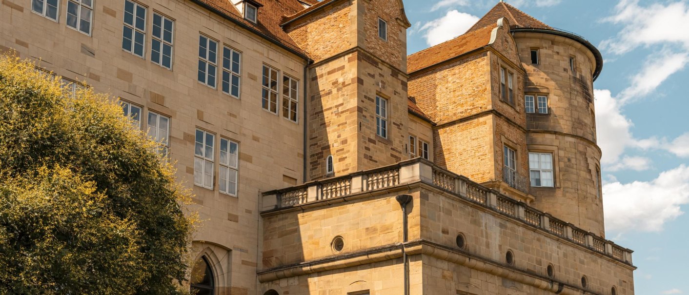 Ein altes Schloss mit markanten Türmen und vielen Fenstern, umgeben von einem blauen Himmel und einigen Wolken., © Stuttgart-Marketing GmbH, Sarah Schmid