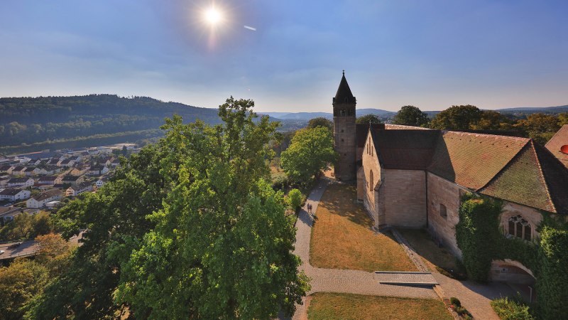 Kloster Lorch im Sonnenschein, umgeben von Bäumen und Hügeln. Im Hintergrund eine Stadt und bewaldete Hügel., © Stuttgart-Marketing GmbH, Achim Mende