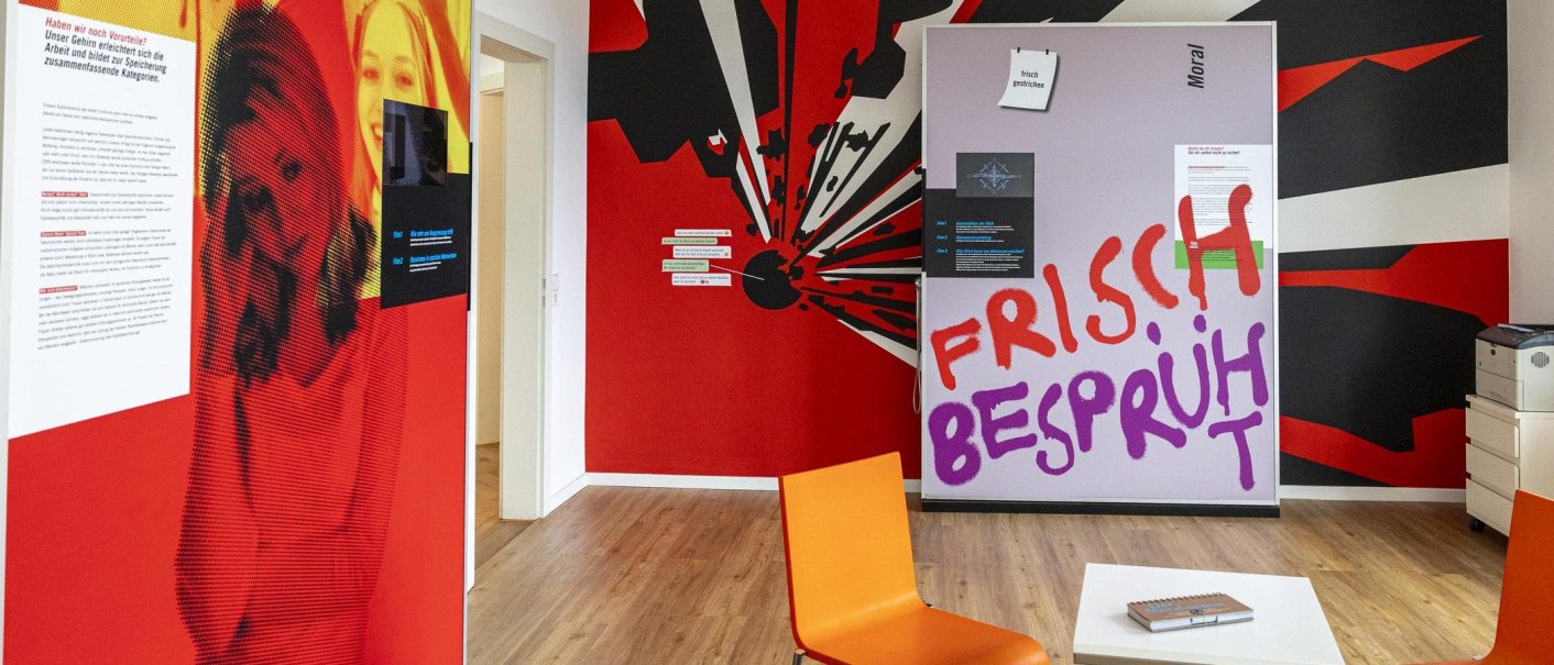 Bunter Ausstellungsraum mit Texten und Grafiken zur Psychologie. Ein orangefarbener Stuhl und ein Tisch mit einem Buch sind sichtbar., © Stuttgart-Marketing GmbH, Sarah Schmid Bunter Ausstellungsraum mit Texten und Grafiken zur Psychologie. Ein orangefarbener Stuhl und ein Tisch mit einem Buch sind sichtbar., © Stuttgart-Marketing GmbH, Sarah Schmid