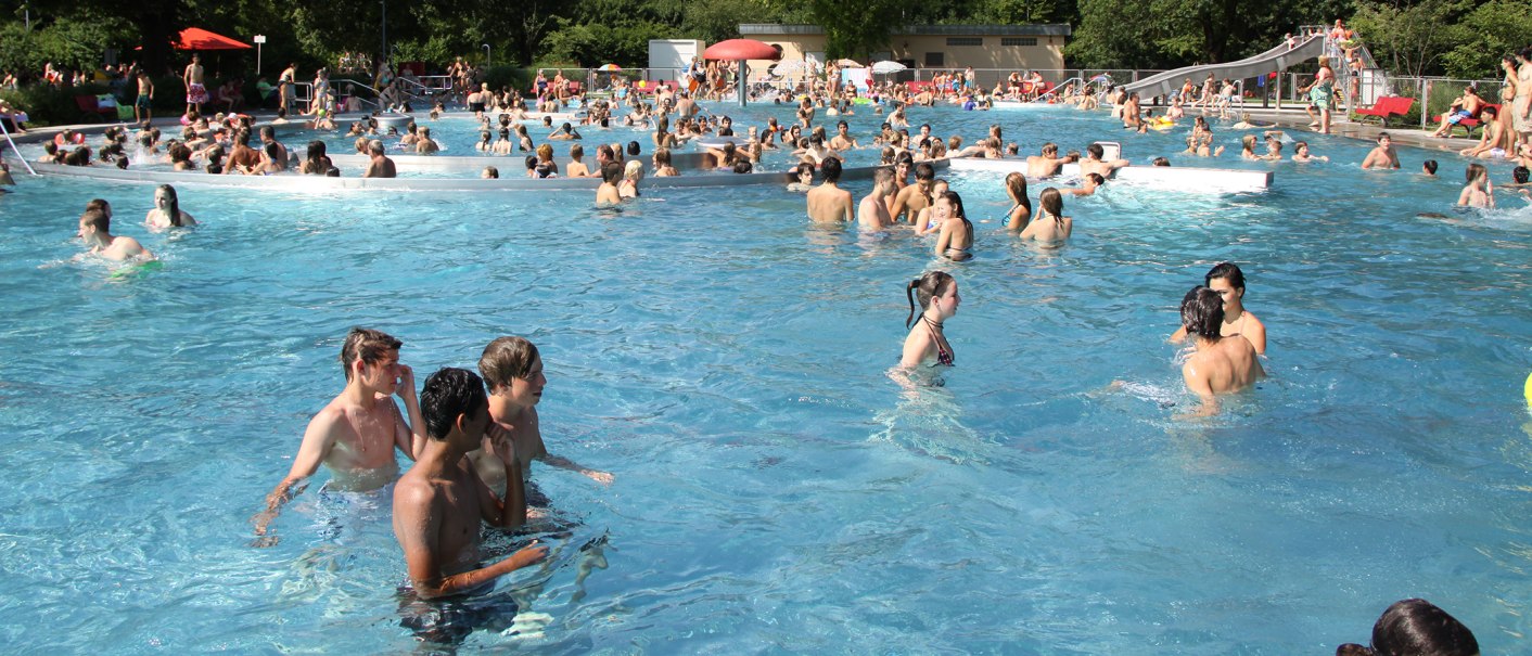 Viele Menschen genießen einen sonnigen Tag im Freibad Kirchheim unter Teck. Das Becken ist voll mit Schwimmern und es herrscht eine lebhafte Atmosphäre., © Torsten Wenzler