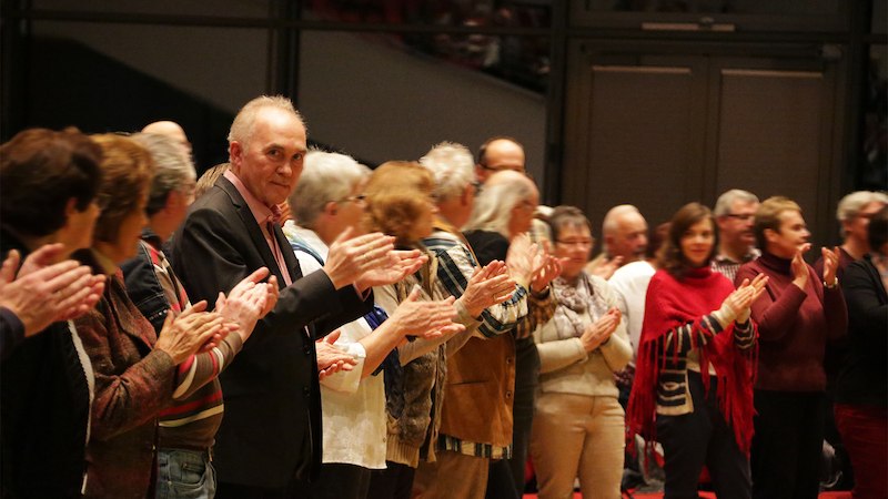 Eine Gruppe von Menschen steht in einer Reihe und applaudiert in einem Veranstaltungsraum. Die Atmosph&auml;re wirkt festlich und gemeinschaftlich., &copy; Sch&ouml;nblick gemeinn&uuml;tzige GmbH