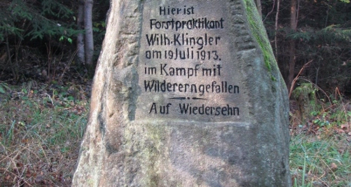 Gedenkstein im Wald erinnert an Forstpraktikant Wilh. Klingler, der 1913 im Kampf mit Wilderern fiel. Umgeben von Bäumen und Gras., © Natur.Nah. Schönbuch & Heckengäu Gedenkstein im Wald erinnert an Forstpraktikant Wilh. Klingler, der 1913 im Kampf mit Wilderern fiel. Umgeben von Bäumen und Gras., © Natur.Nah. Schönbuch & Heckengäu