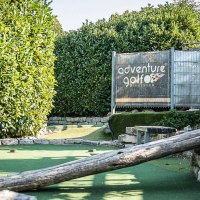 Adventure-Golfanlage in Winnenden mit gr&uuml;nem Kunstrasen und Holzhindernis, umgeben von &uuml;ppigem Gr&uuml;n., &copy; Adventuregolf Winnenden