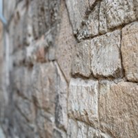 Nahaufnahme einer alten Steinmauer mit groben, rechteckigen Steinen. Die Struktur und Maserung der Steine sind deutlich sichtbar., © Touristik und Marketing GmbH