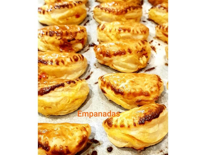 Goldbraune Empanadas auf einem Backblech, frisch gebacken und glänzend. Der Schriftzug "Empanadas" ist auf dem Bild zu sehen., © Kultweine-Kochwelten-Kunstücke - Kochschule Sonja Lenz Goldbraune Empanadas auf einem Backblech, frisch gebacken und glänzend. Der Schriftzug "Empanadas" ist auf dem Bild zu sehen., © Kultweine-Kochwelten-Kunstücke - Kochschule Sonja Lenz