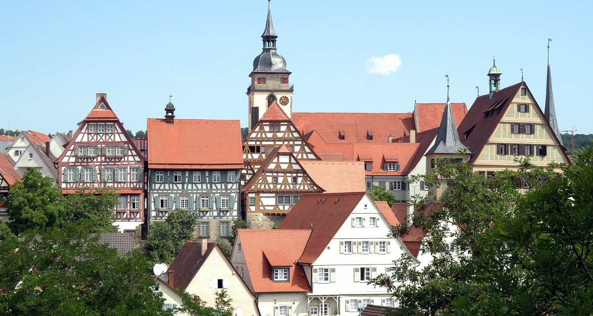 Historische Altstadt mit Fachwerkhäusern und einem Kirchturm, umgeben von grünen Bäumen. Der Himmel ist klar und blau., © Land der 1000 Hügel - Kraichgau-Stromberg Historische Altstadt mit Fachwerkhäusern und einem Kirchturm, umgeben von grünen Bäumen. Der Himmel ist klar und blau., © Land der 1000 Hügel - Kraichgau-Stromberg