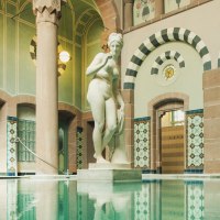 Historisches Schwimmbecken mit kunstvollen Fliesen und einer Statue in einem eleganten, gewölbten Raum., © ©LOCHER Fotodesign & Manufaktur ©Staatsbad Wildbad GmbH Historisches Schwimmbecken mit kunstvollen Fliesen und einer Statue in einem eleganten, gewölbten Raum., © ©LOCHER Fotodesign & Manufaktur ©Staatsbad Wildbad GmbH