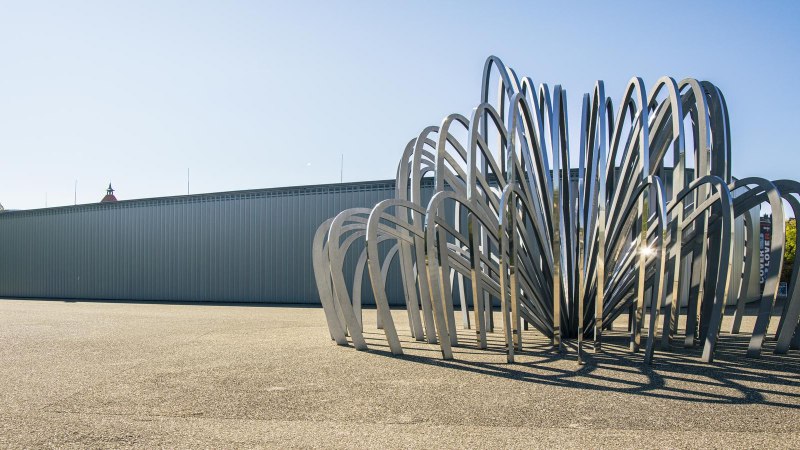 Moderne Skulptur aus gebogenen Metallstreben vor der Galerie Stihl in Waiblingen, bei klarem Himmel und Sonnenschein., © SMG, Sarah Schmid