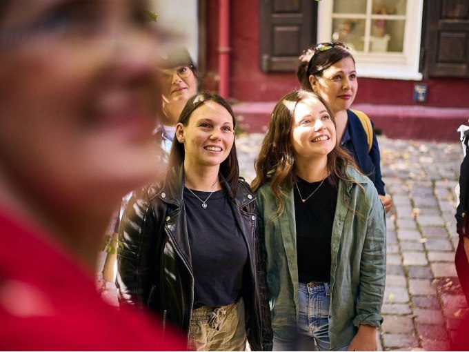 Mehrere Personen stehen auf einem gepflasterten Weg und blicken lächelnd in eine Richtung. Im Hintergrund sind bunte Gebäude zu sehen., © Esslinger Stadtmarketing & Tourismus GmbH Mehrere Personen stehen auf einem gepflasterten Weg und blicken lächelnd in eine Richtung. Im Hintergrund sind bunte Gebäude zu sehen., © Esslinger Stadtmarketing & Tourismus GmbH