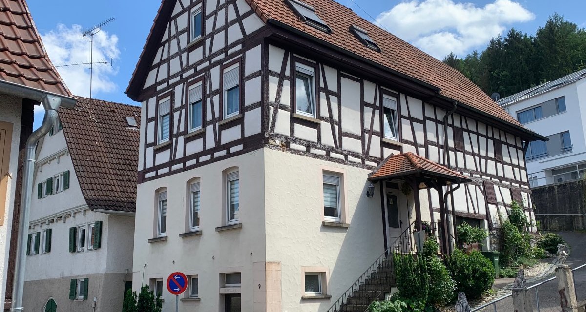 Fachwerkhaus mit rotem Dach und Eingangstreppe. Es steht in einer Wohngegend mit weiteren H&auml;usern und einem blauen Himmel im Hintergrund., &copy; Land der 1000 H&uuml;gel - Kraichgau-Stromberg