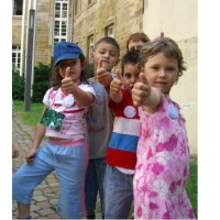F&uuml;nf Kinder stehen in einer Reihe und zeigen den Daumen nach oben. Sie befinden sich vor einem alten Geb&auml;ude mit Backsteinmauern., &copy; Touristik und Marketing GmbH