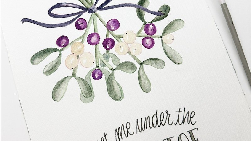 Aquarellbild von Mistelzweigen mit handgeschriebenem Text 'meet me under the mistletoe'. Daneben ein Pinsel und eine Farbpalette., &copy; Mercedes-Benz AG